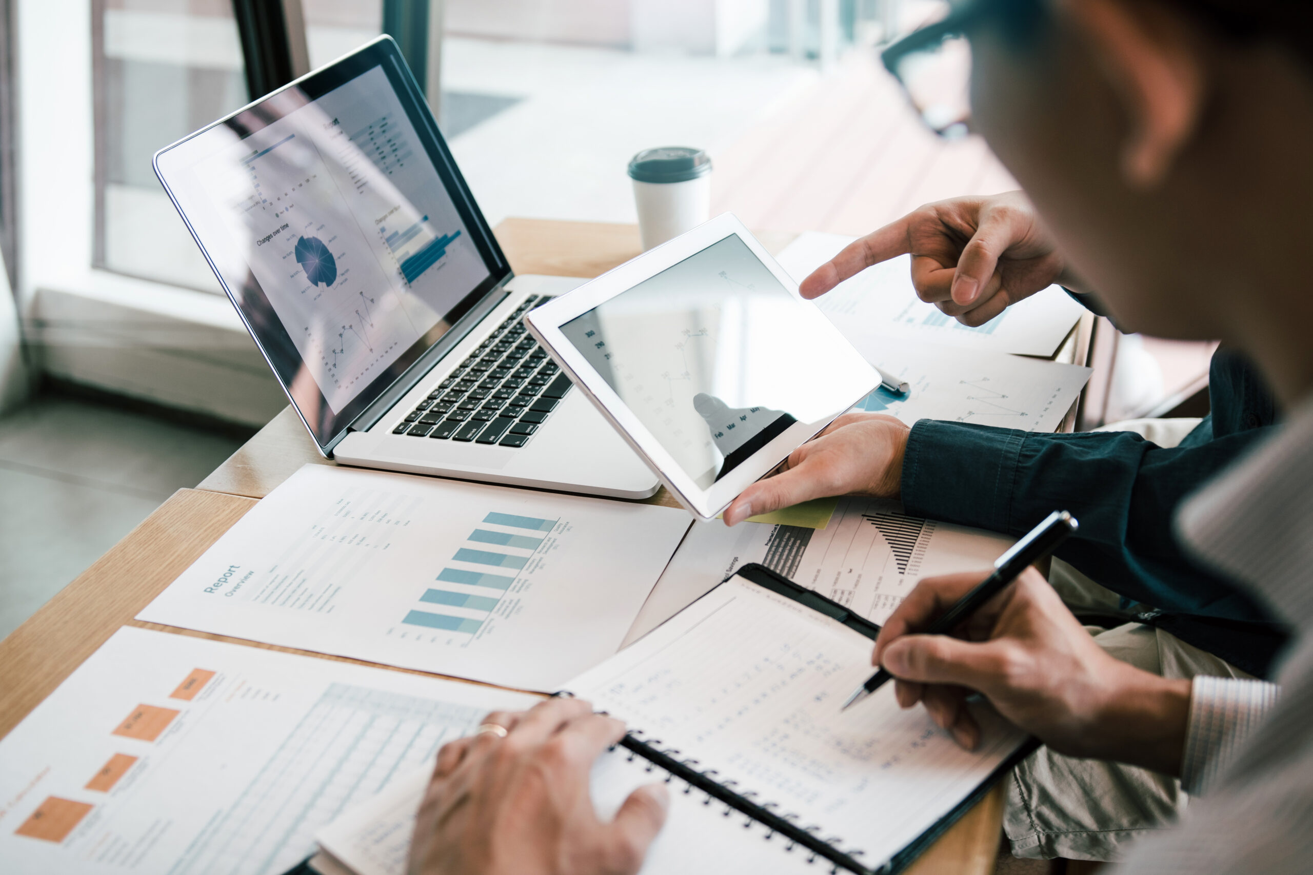 Business partnership coworkers using a tablet to analysis graph Business partnership coworkers using a tablet to analysis graph company financial budget report and cost work progress and planning for future in office room.